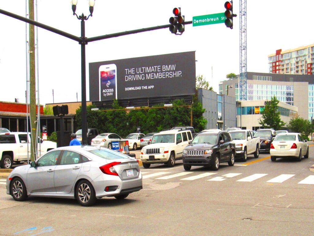 City street with cars and traffic lights near Music Row Tower.