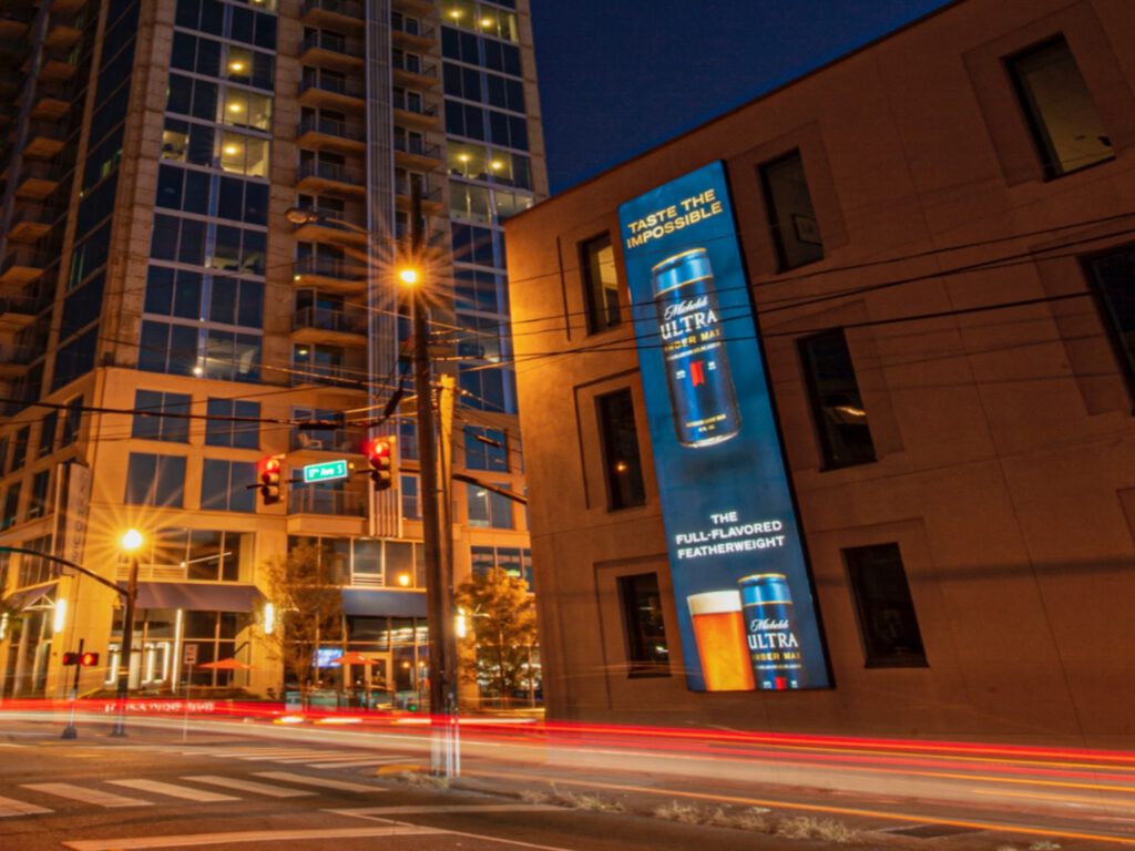 Digital billboard advertising Ultra beer in downtown city at night.