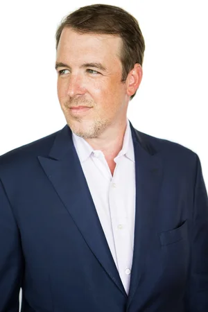Businessman in navy suit looking to the side for About page.